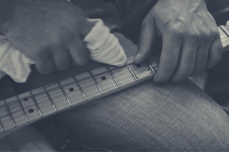 Cleaning a guitar fretboard with a cloth