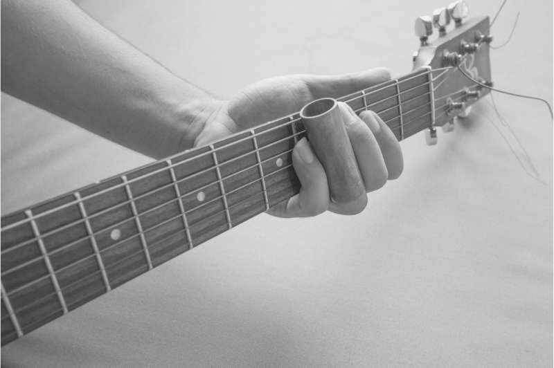 Man playing guitar neck close up