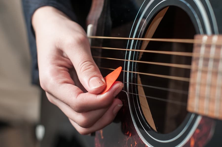 Playing guitar with a big guitar pick