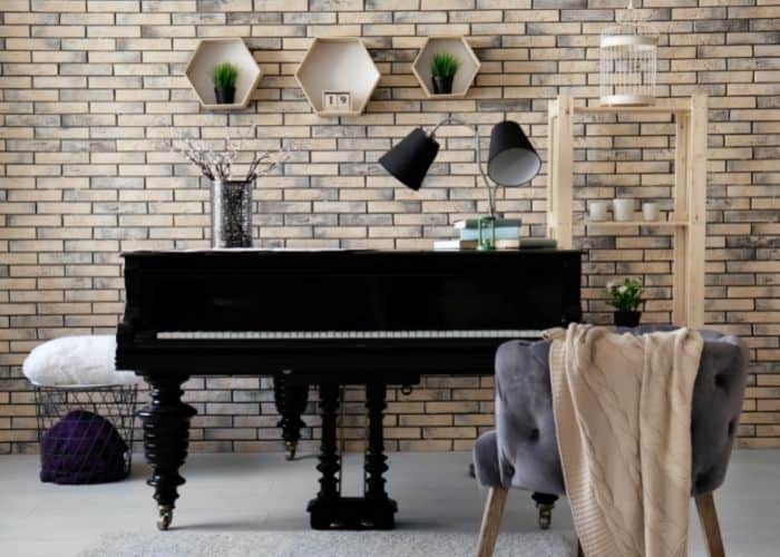 music room with piano and brick wall